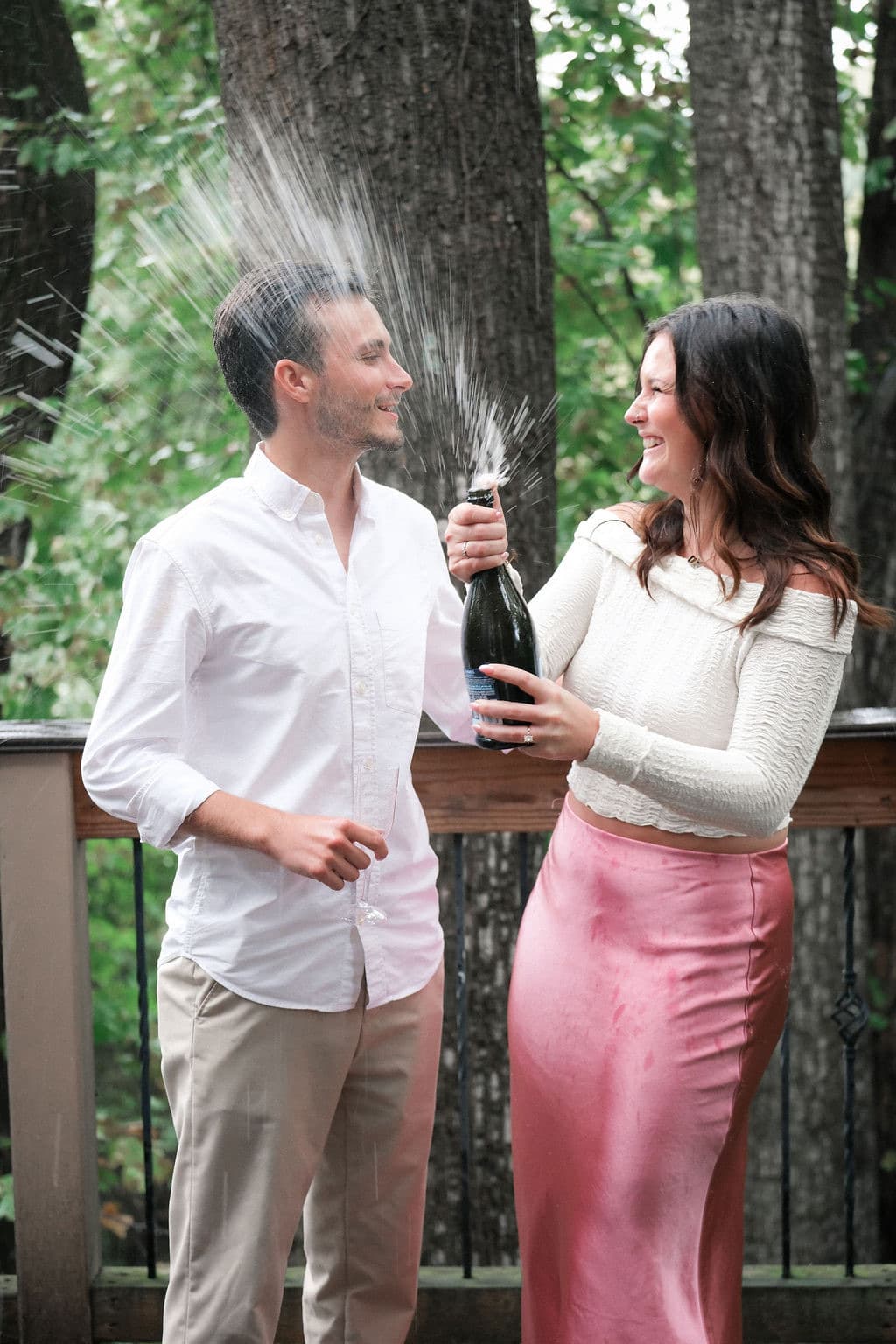 Caroline laughing as champagne sprays past Chandler