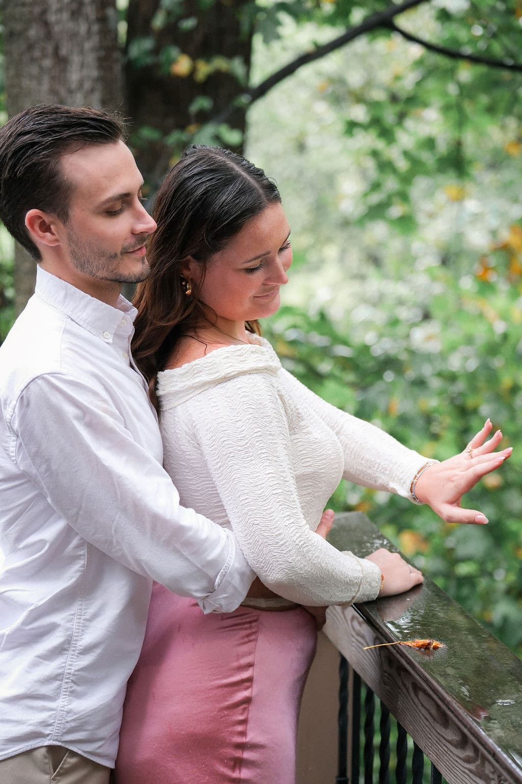 The couple at the deck railing, Caroline's ring hand outstretched