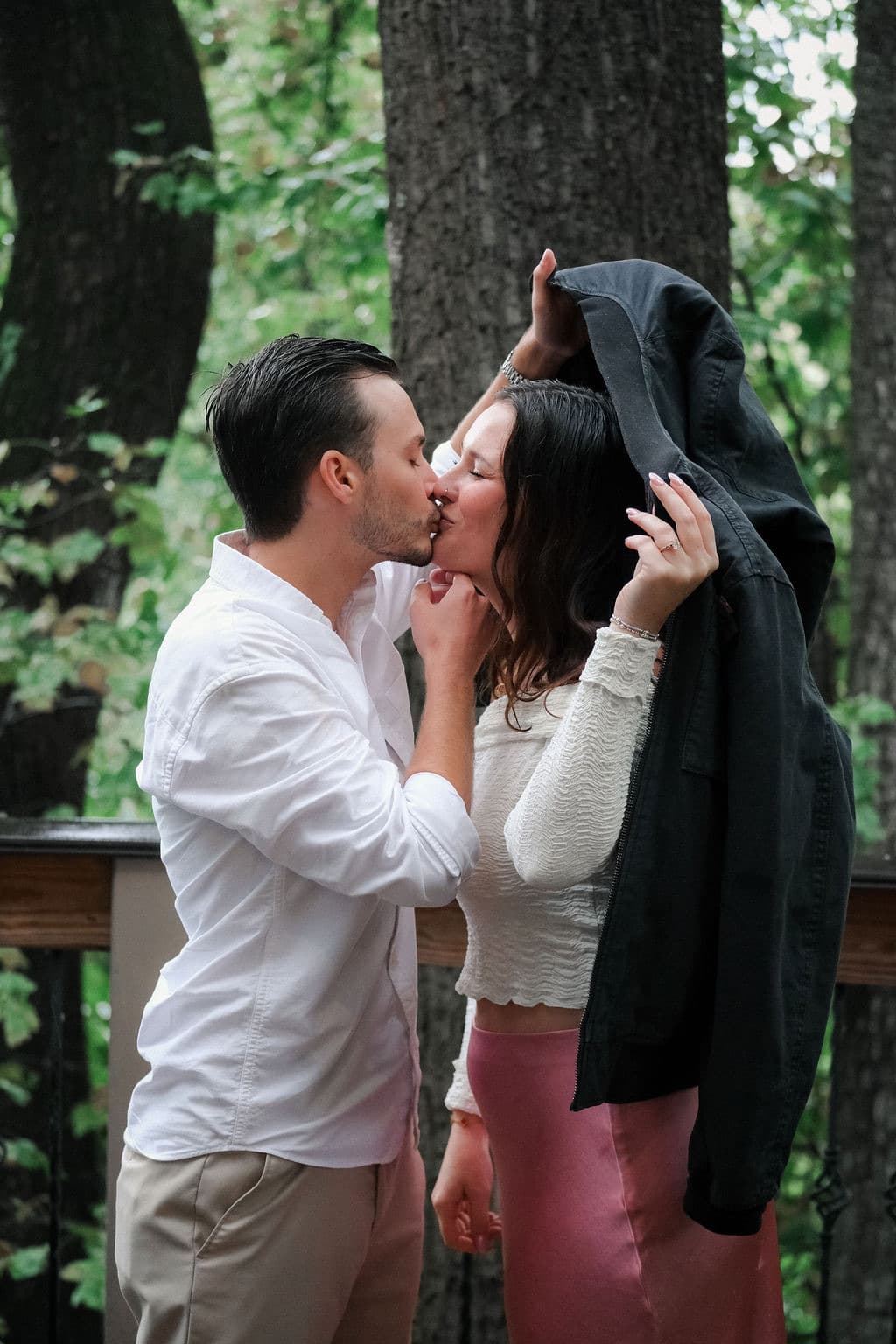 A kiss under a jacket in the rain